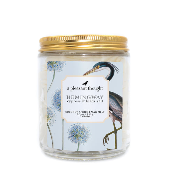 hemingway cypress and black salt Scoopable coconut apricot wax melt whipped into a clear glass jar with a gold lid and spoon a pleasant thought