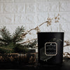 white musk violet edgar black coconut apricot wax candle in a matte black glass vessel with a wooden wick a pleasant thought displayed