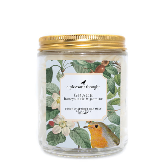 grace honeysuckle and jasmine Scoopable coconut apricot wax melt whipped into a clear glass jar with a gold lid and spoon a pleasant thought