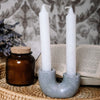 handmade concrete candlestick holder in light grey with white splatter.  White tapered candles