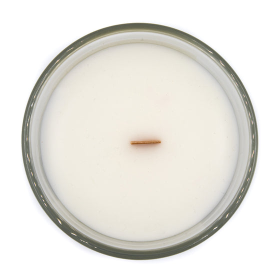 hemingway cypress and black salt coconut apricot wax candle in a clear glass vessel with a wooden wick top
