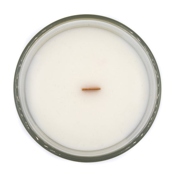 eden ripe berries and sweet citrus A coconut apricot wax candle in a classic, clear glass vessel with a wooden wick top