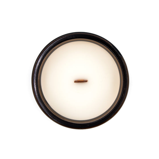 circe sage and wild mint coconut apricot wax candle in an amber glass jar with a wooden wick and lid top