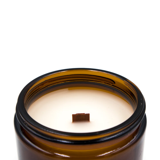 moriarty bergamot and white tea coconut apricot wax candle in a classic, amber glass jar with a wooden wick and lid top side