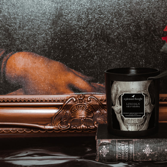 oak whiskey lincoln black coconut apricot wax candle in a matte black glass vessel with a wooden wick a pleasant thought in use