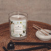 ophelia peach blossom and basil coconut apricot wax candle in a classic, clear glass votive with a wooden wick display