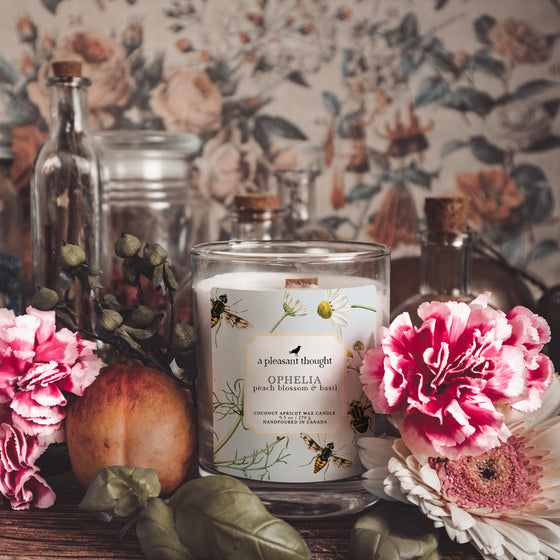 ophelia peach blossom and basil coconut apricot wax candle in a classic, clear glass votive with a wooden wick notes