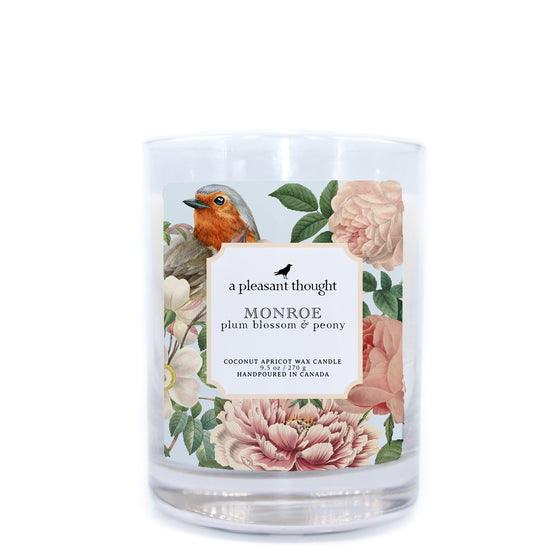 monroe plum blossom and peony coconut apricot wax candle in a classic, clear glass vessel with a wooden wick  a pleasant thought