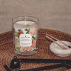 monroe plum blossom and peony coconut apricot wax candle in a classic, clear glass vessel with a wooden wick display