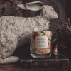 monroe plum blossom and peony coconut apricot wax candle in a classic, clear glass vessel with a wooden wick display