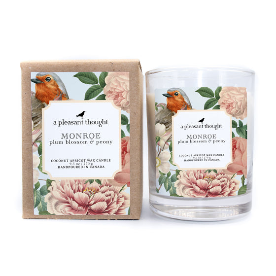 monroe plum blossom and peony coconut apricot wax candle in a classic, clear glass vessel with a wooden wick box