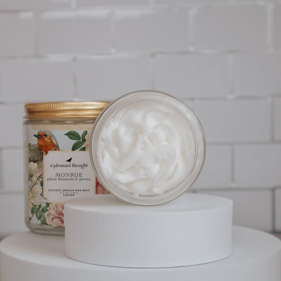 monroe plum blossom and peony Scoopable coconut apricot wax melt whipped into a clear glass jar with a gold lid and spoon open