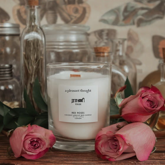 red roses inspiration for rani red roses coconut apricot wax candle in a classic, clear glass votive with a wooden wick tamil candle  notes