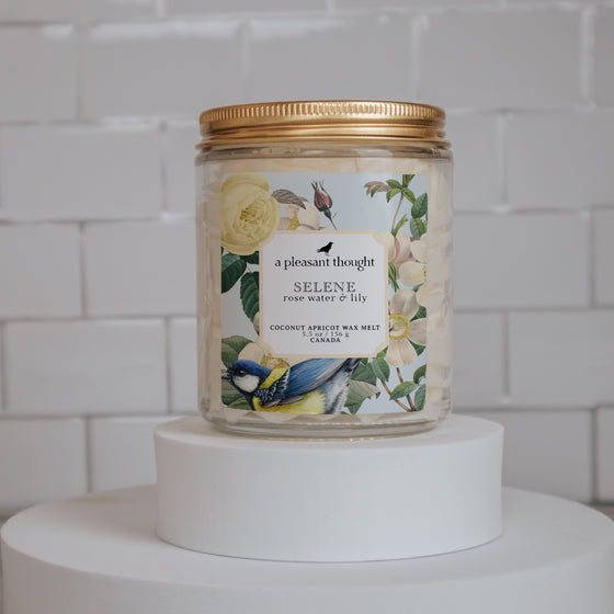 selene rose water and lily Scoopable coconut apricot wax melt whipped into a clear glass jar with a gold lid and spoon