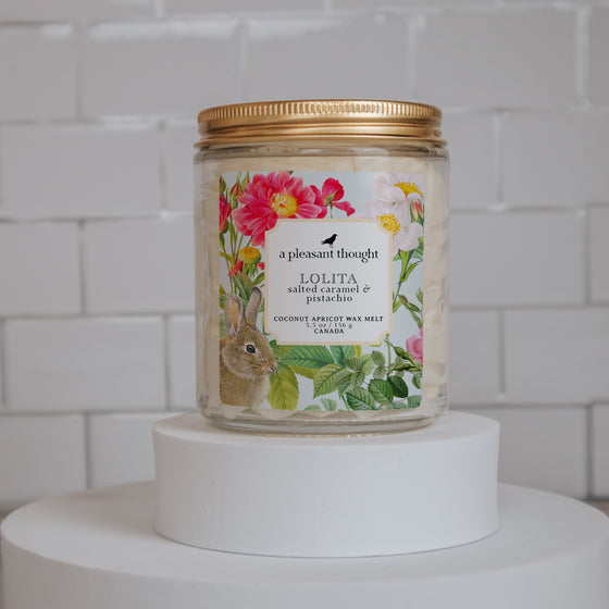 lolita salted caramel and pistachio Scoopable coconut apricot wax melt whipped into a clear glass jar with a gold lid and spoon