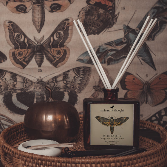 moriarty bergamot & white tea Fragranced diffuser oil housed in an amber glass, apothecary bottle with rattan reeds display