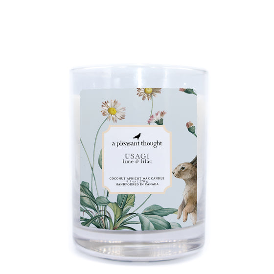 usagi lime and lilac coconut apricot wax candle in a classic, clear glass votive with a wooden wick a pleasant thought