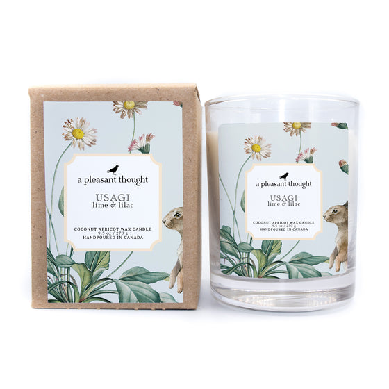 usagi lime and lilac coconut apricot wax candle in a classic, clear glass votive with a wooden wick box