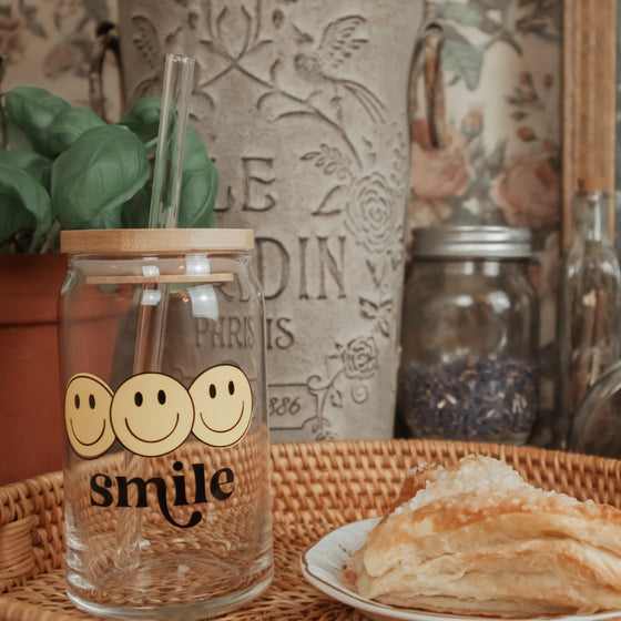 smile on a beer can glass with lid and straw