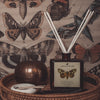 samsara spiced sandalwood Fragranced diffuser oil housed in an amber glass, apothecary bottle with rattan reeds  display