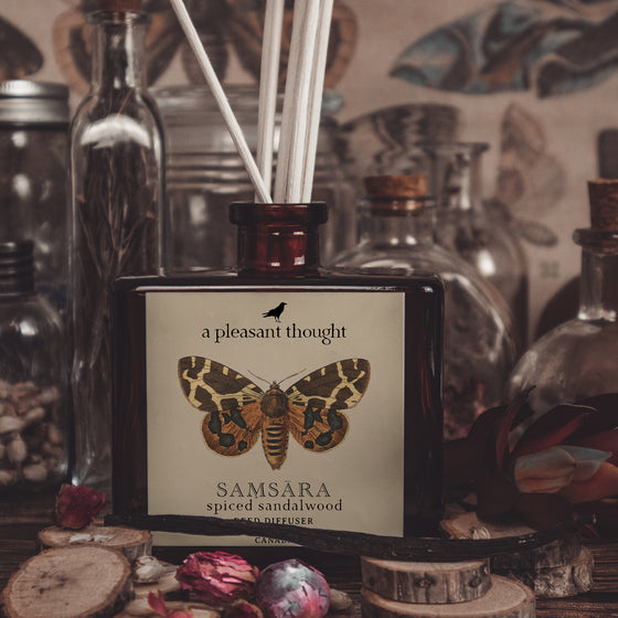 samsara spiced sandalwood Fragranced diffuser oil housed in an amber glass, apothecary bottle with rattan reeds  notes